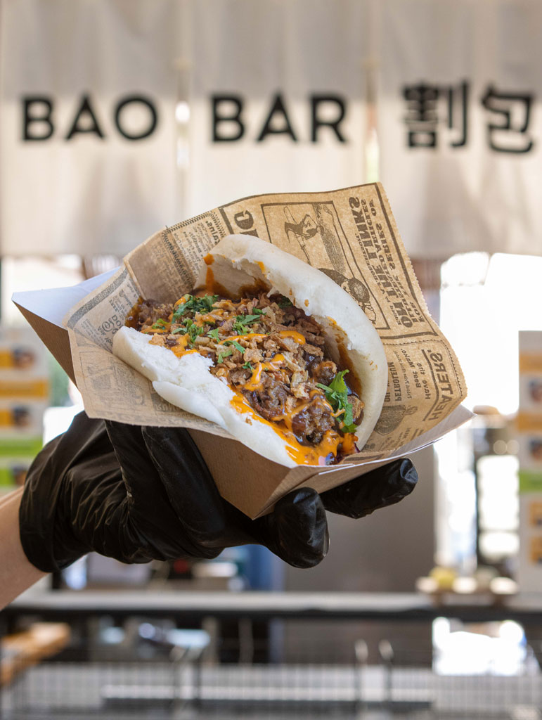 Animation street food Bao Bar – Nomad x Mama Bao, stand mobile événementiel Gua bao garni servi à la main sur le stand Bao Bar Nomad x Mama Bao, animation street food asiatique mobile et conviviale pour événement haut de gamme